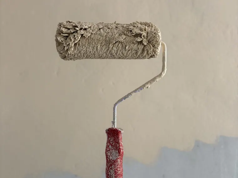 Rolo de pintura aplicando tinta em parede